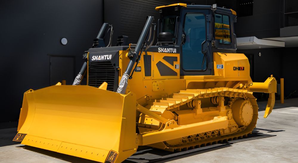 A Yellow Bulldozer is Parked in Front of a Building — Rowdraulics NQ Pty Ltd in Mount Louisa, QLD