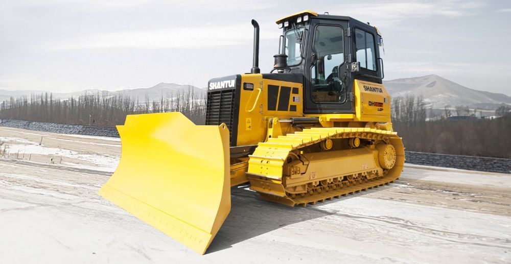 A Yellow Bulldozer is Driving Down a Snowy Road — Rowdraulics NQ Pty Ltd in Mount Louisa, QLD