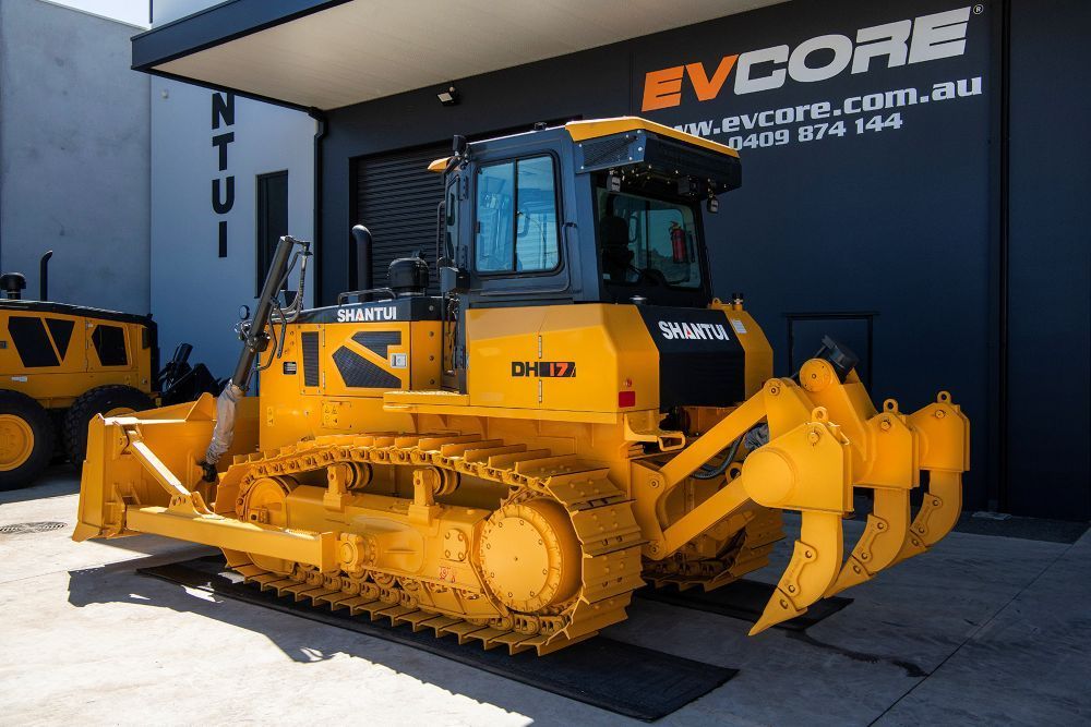 A Yellow Bulldozer is Parked in Front of a Building That Says Evcore — Rowdraulics NQ Pty Ltd in Mount Louisa, QLD