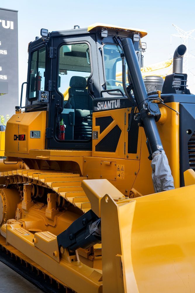 A Yellow Bulldozer is Parked in Front of a Building — Rowdraulics NQ Pty Ltd in Mount Louisa, QLD