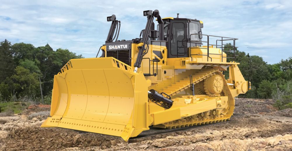 A Large Yellow Bulldozer is Driving Through a Dirt Field — Rowdraulics NQ Pty Ltd in Mount Louisa, QLD