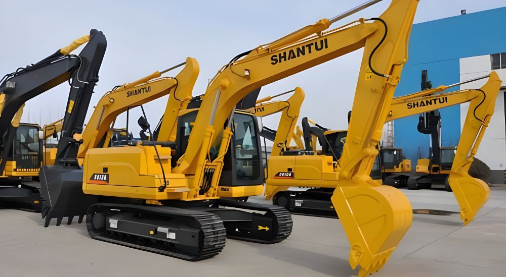 A Row of Yellow Excavators Are Parked in Front of a Building — Rowdraulics NQ Pty Ltd in Mount Louisa, QLD