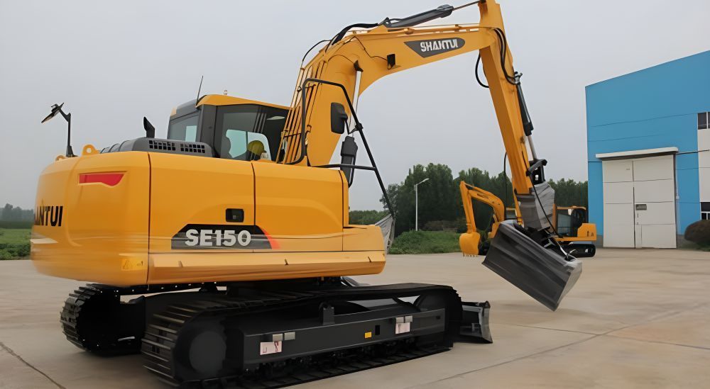 A Yellow Excavator is Parked in Front of a Blue Building — Rowdraulics NQ Pty Ltd in Mount Louisa, QLD