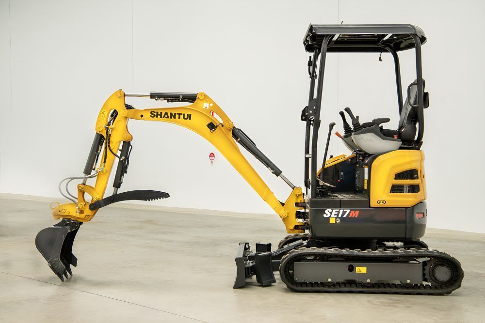 A Small Excavator is Parked in a Parking Lot in Front of a Building — Rowdraulics NQ Pty Ltd in Mount Louisa, QLD