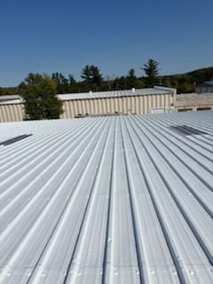 A white metal roof with a blue sky in the background.