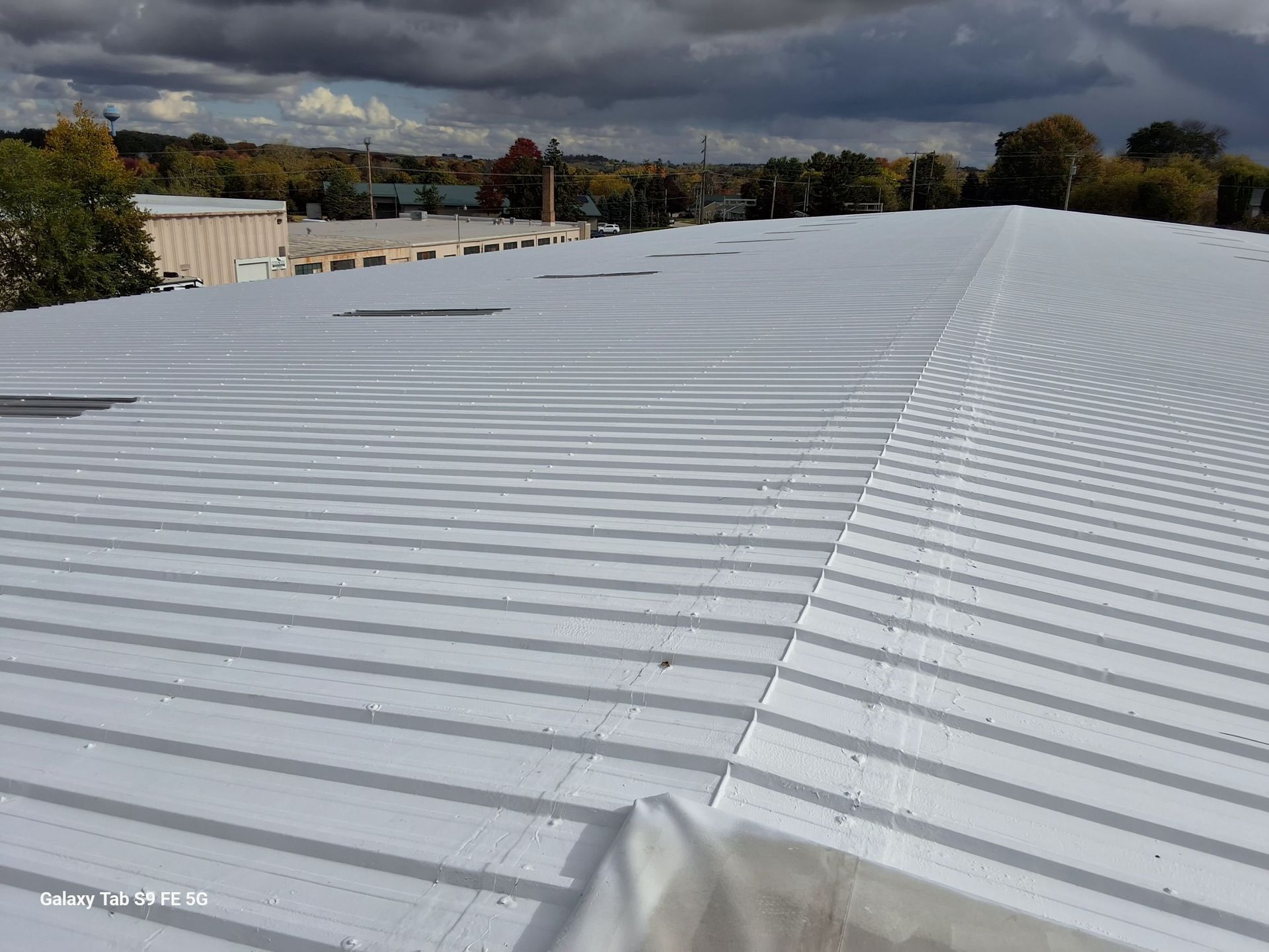 A large white roof with a cloudy sky in the background.