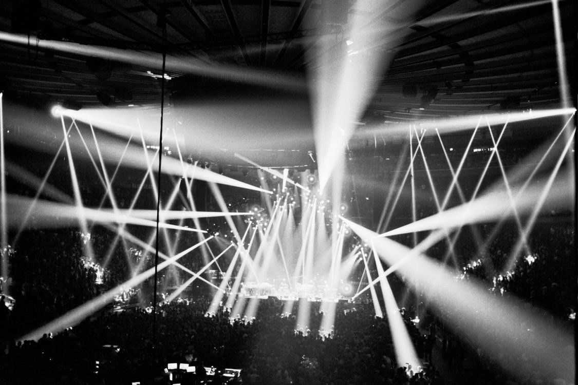A black and white photo of a stage with a lot of lights coming out of it