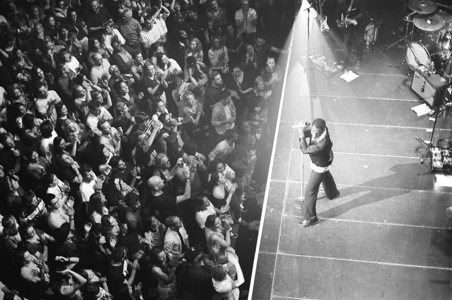 A man singing into a microphone in front of a crowd