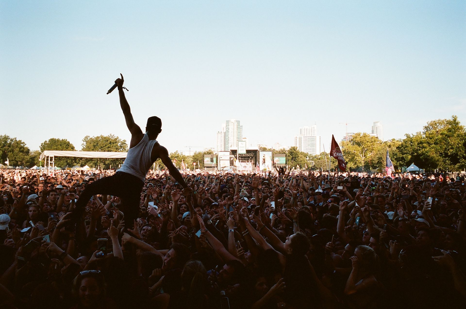 A man is holding a microphone in front of a crowd at a concert.