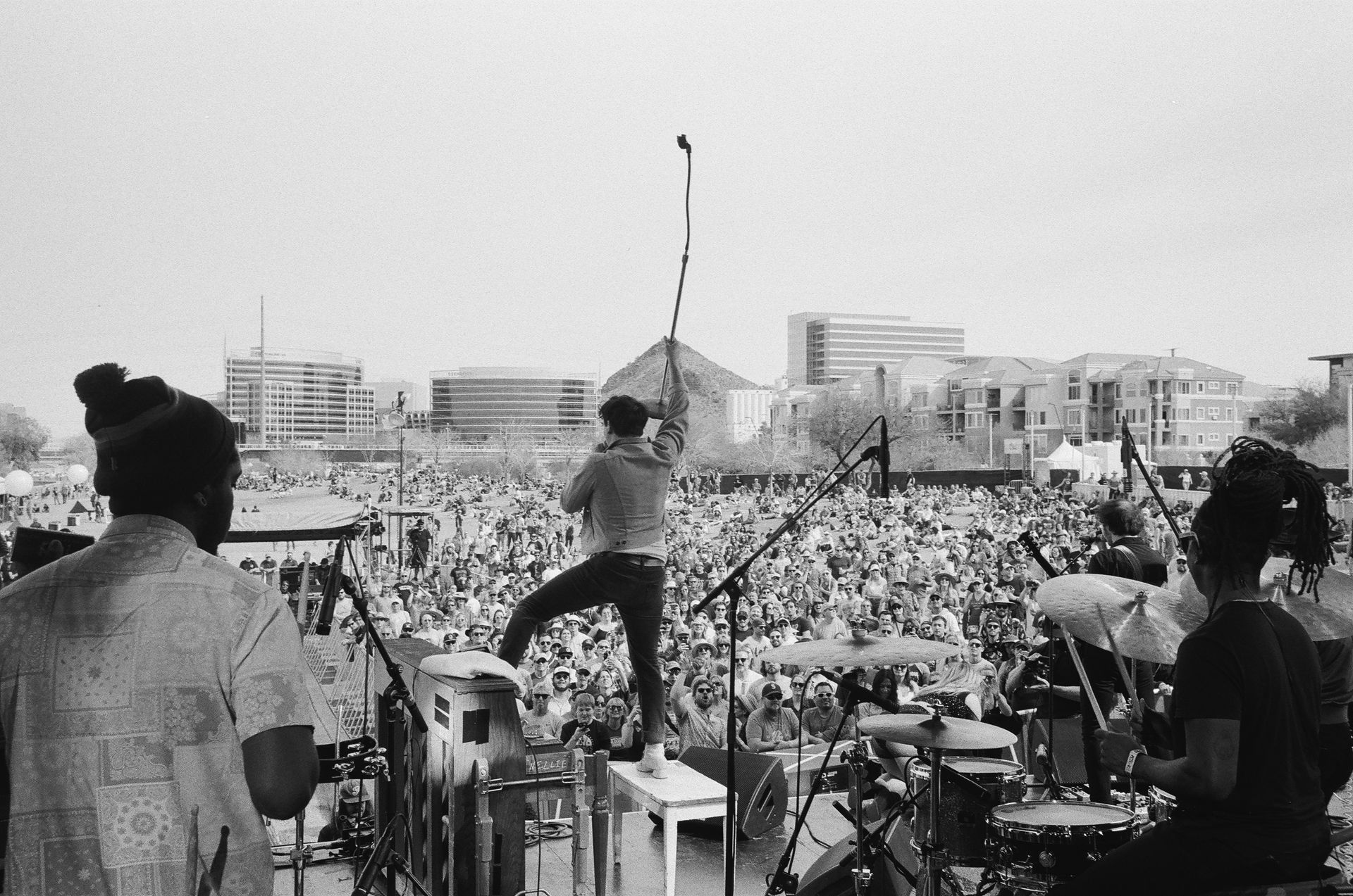 A black and white photo of a band playing in front of a crowd