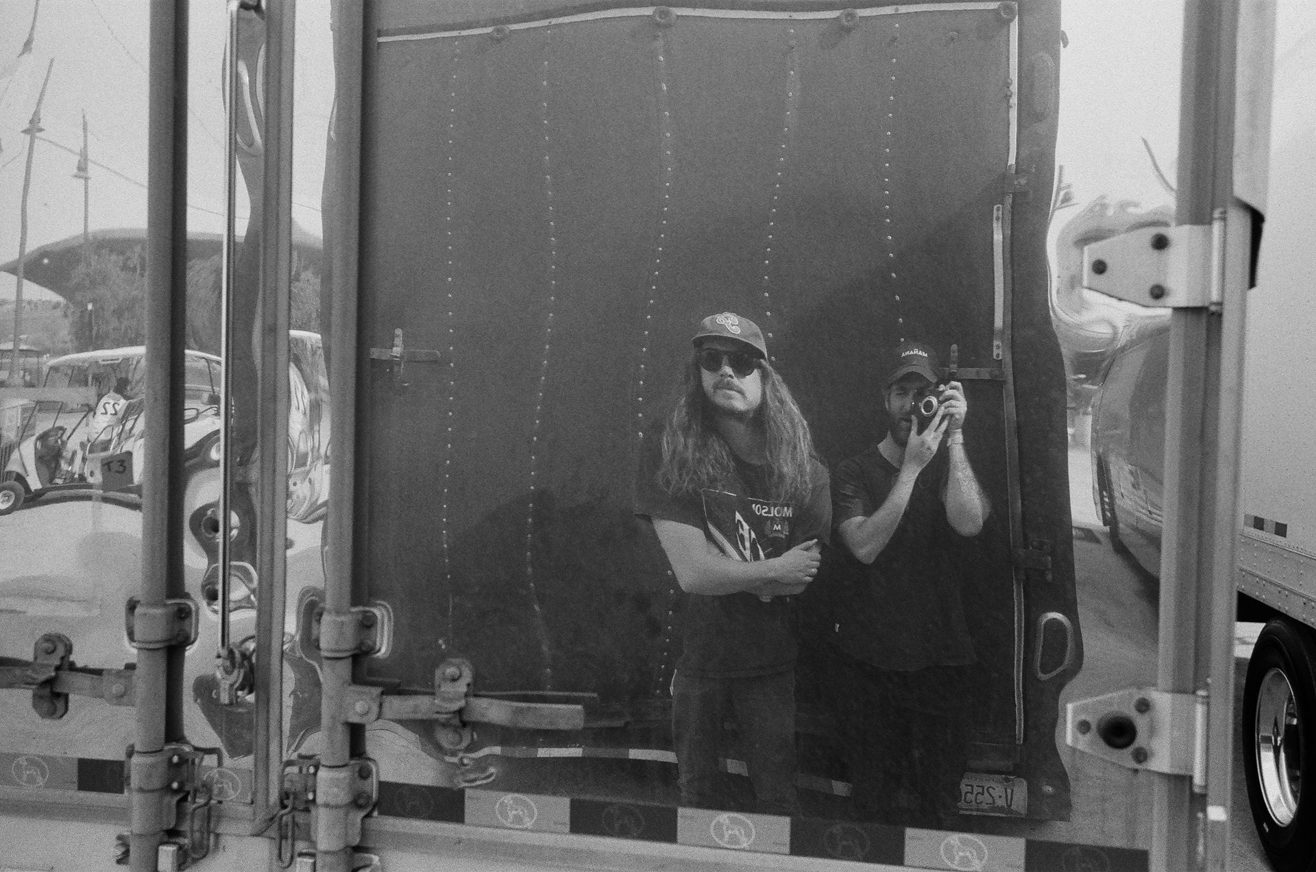 A man is taking a picture of himself in the mirror of a truck.