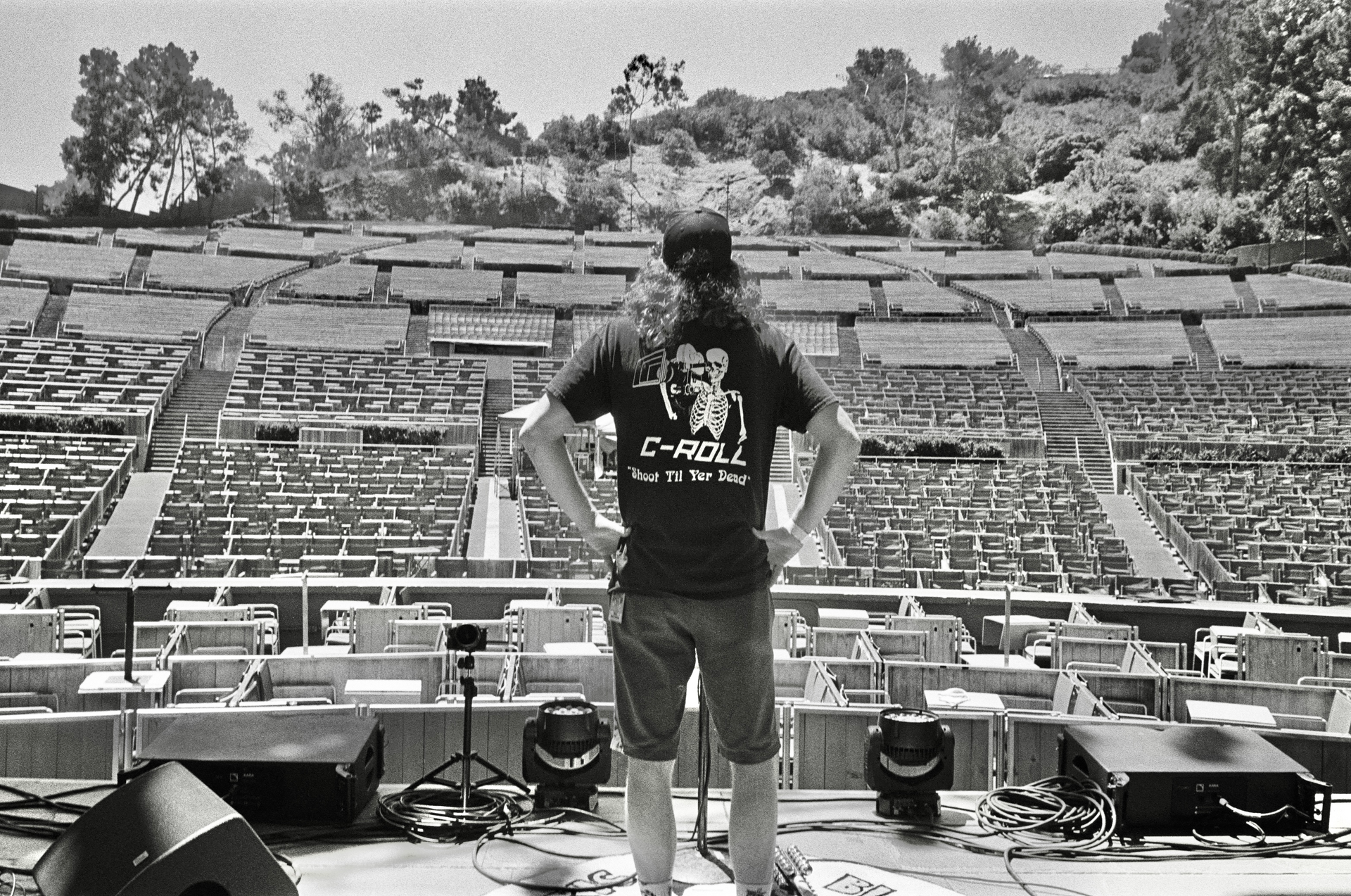 Photo of C.J. of C-Roll Productions standing on the stage of the Hollywood Bowl venue, looking out at the bleachers