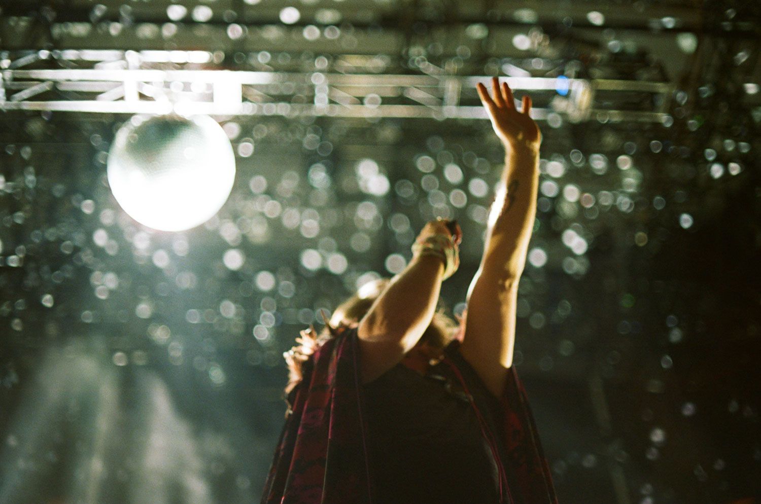 A woman is standing on a stage with her arms in the air.