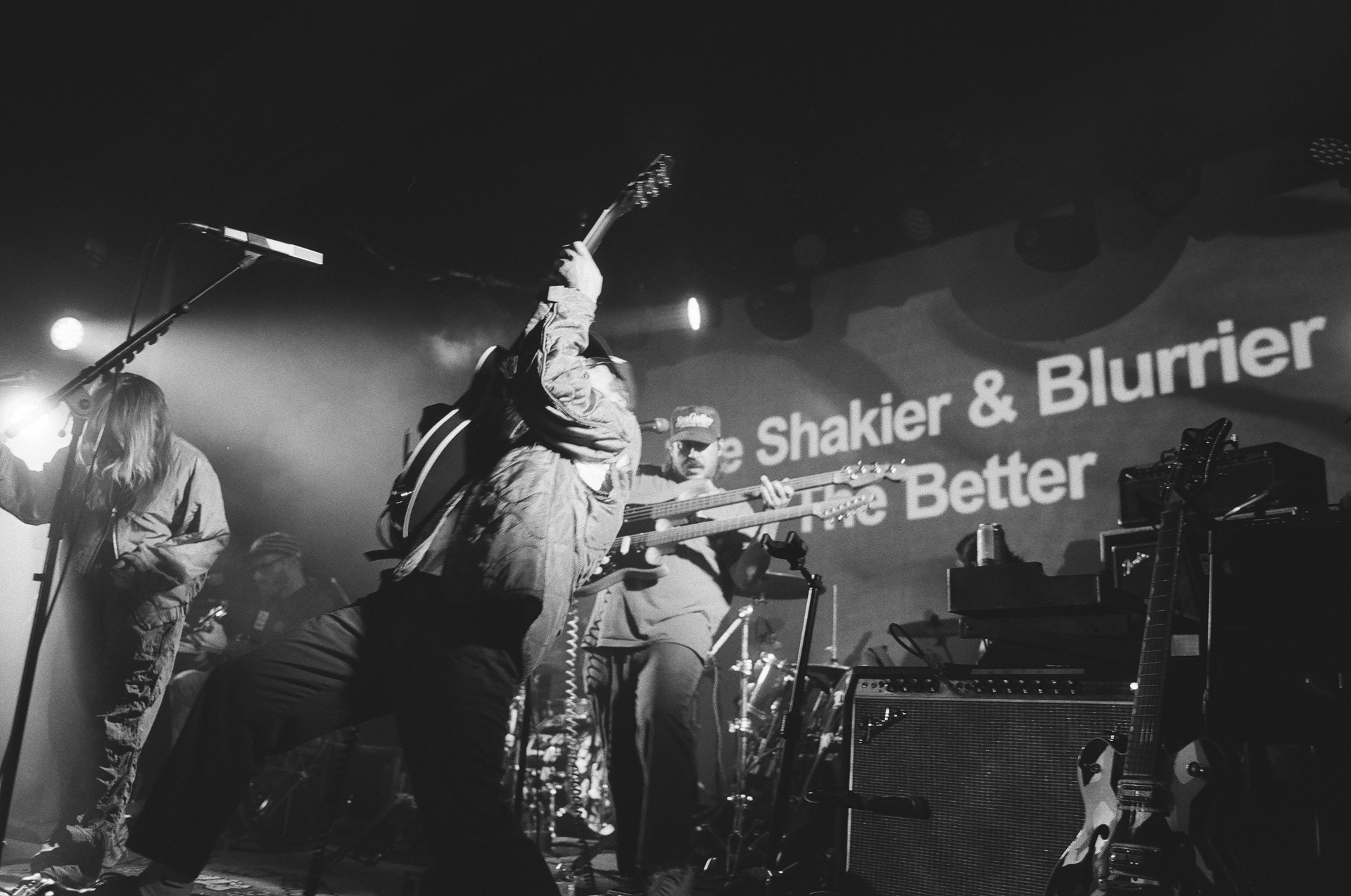 A black and white photo of a band performing on stage