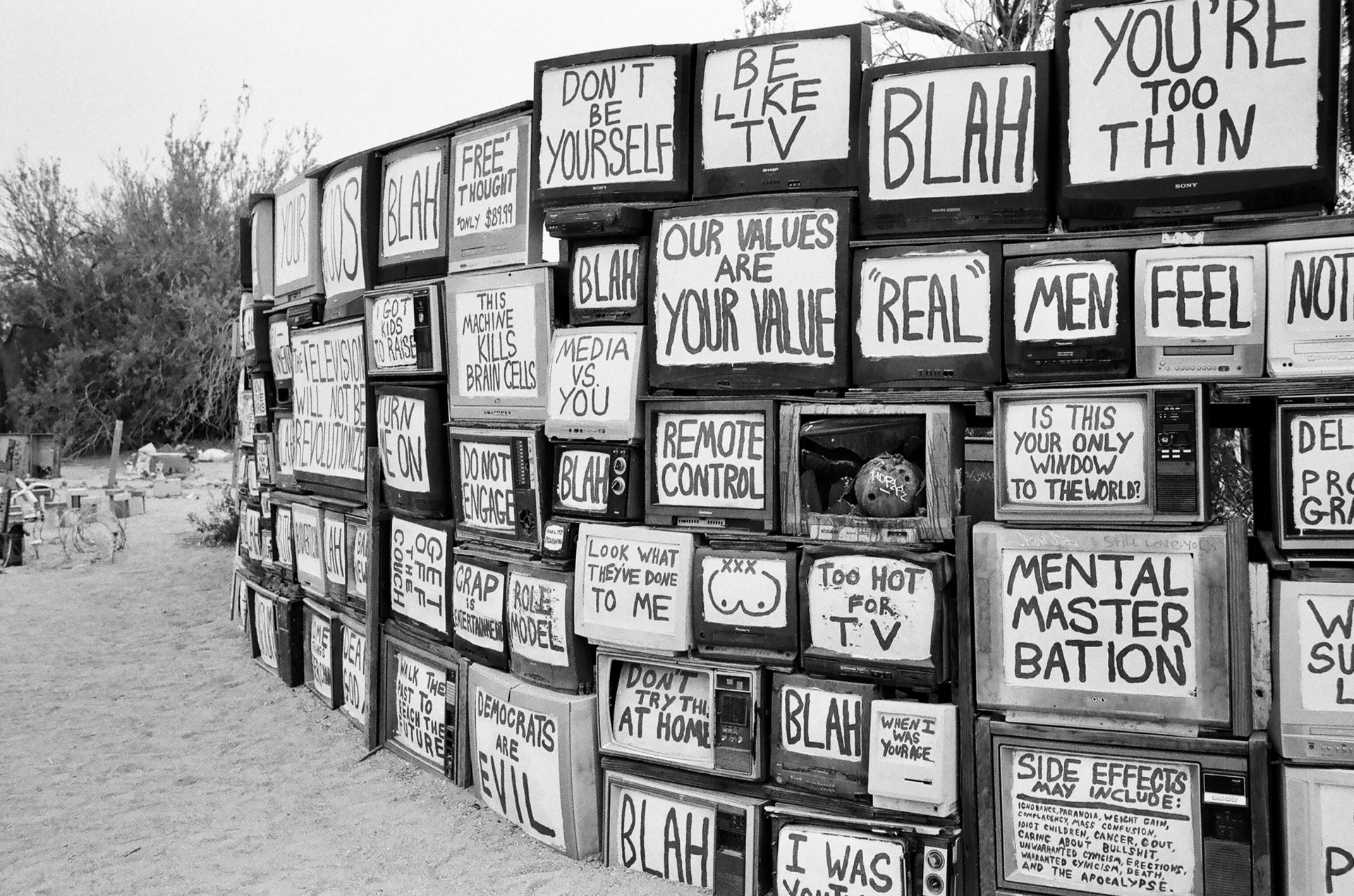A black and white photo of a wall made out of old televisions