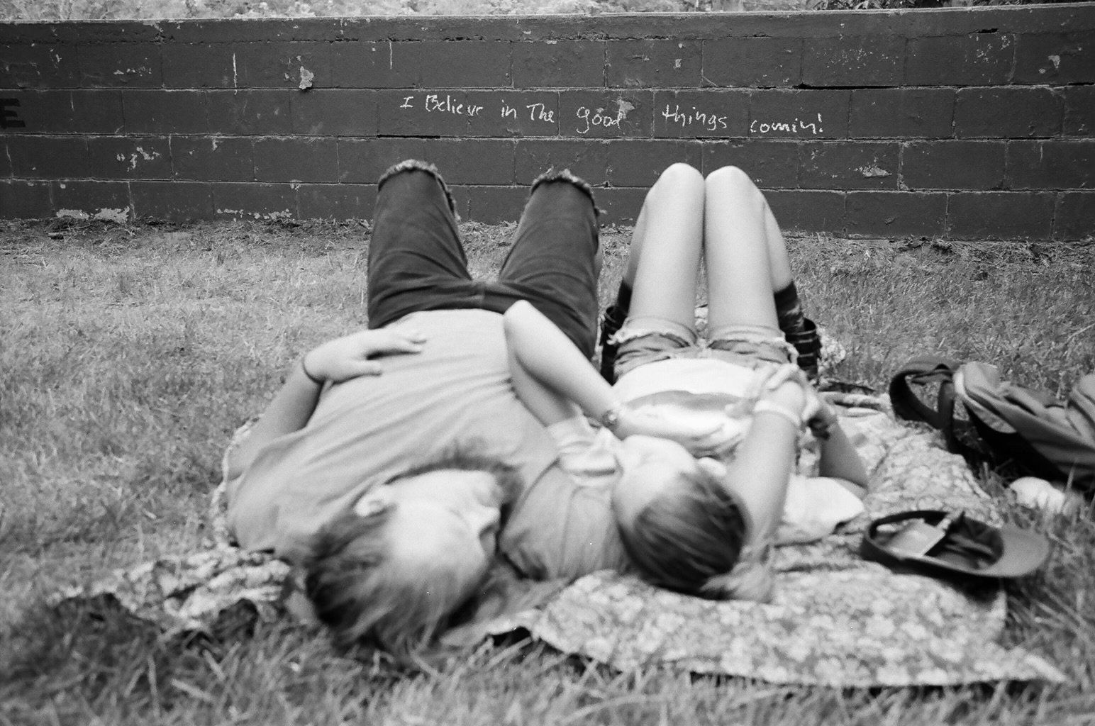 A black and white photo of a man and woman laying on a blanket