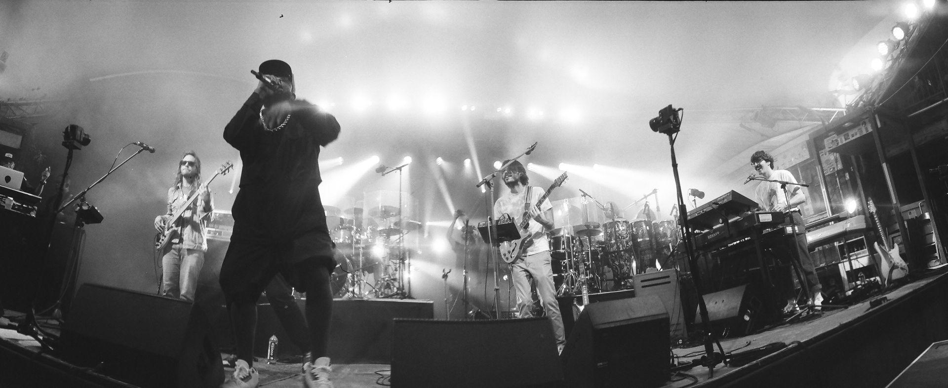 A black and white photo of a man singing into a microphone on a stage.