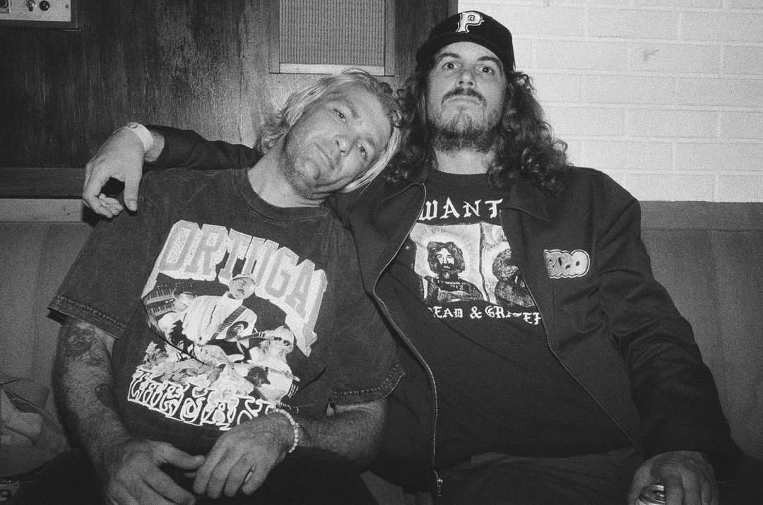 A black and white photo of two men sitting next to each other