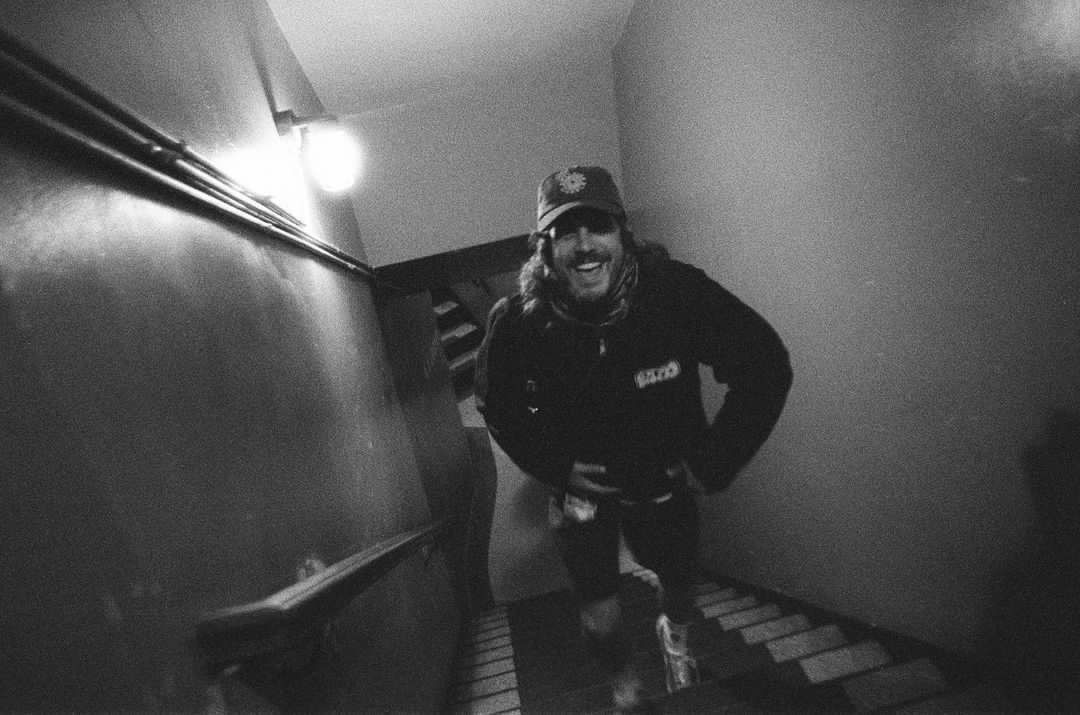 A black and white photo of a man walking down stairs.