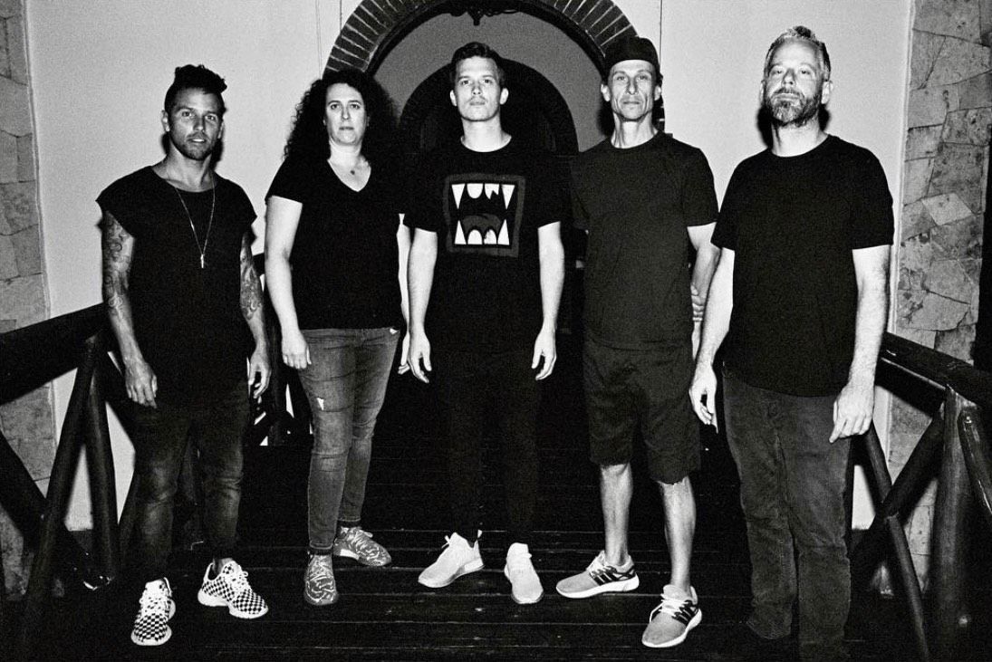 A group of people standing next to each other in a black and white photo.