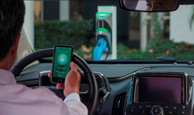 Person using EV charging app on smartphone to locate nearby stations by MyEVExperts
