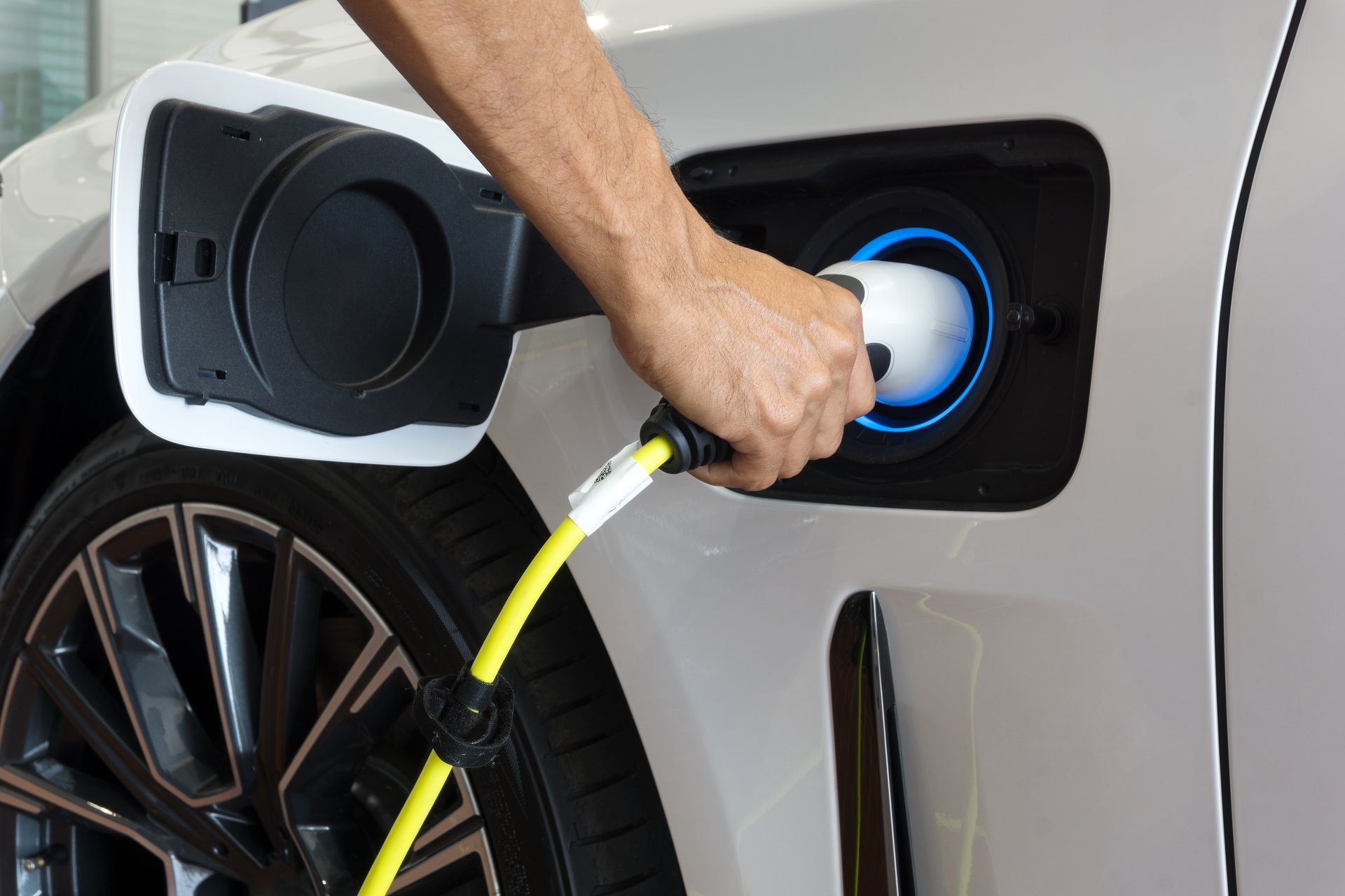 A person is charging an electric car with a charger.