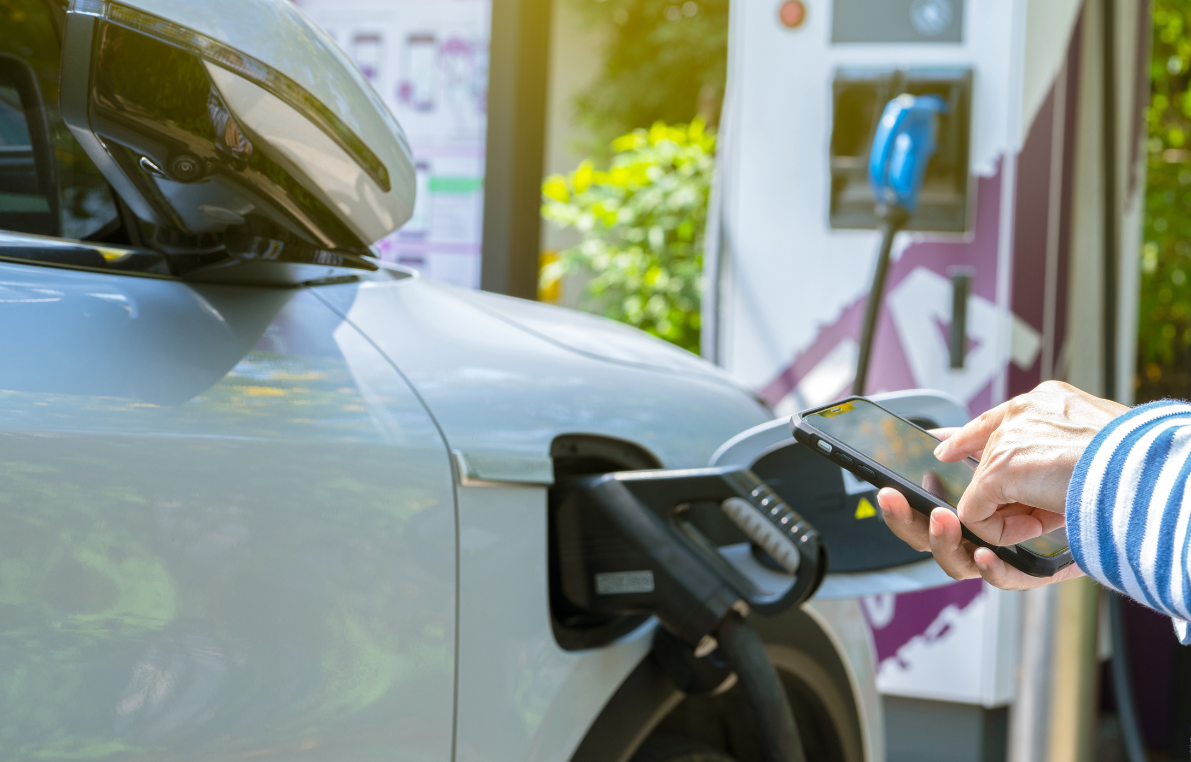 A person is charging an electric car at a charging station.