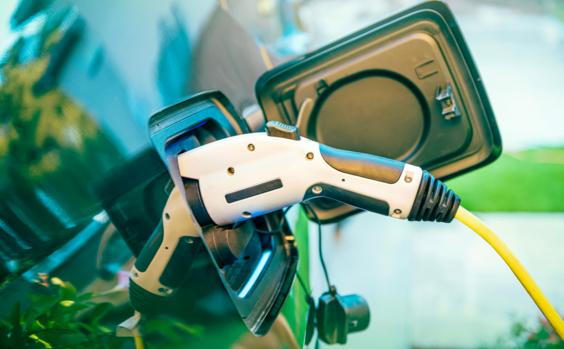 An electric car is being charged at a charging station.