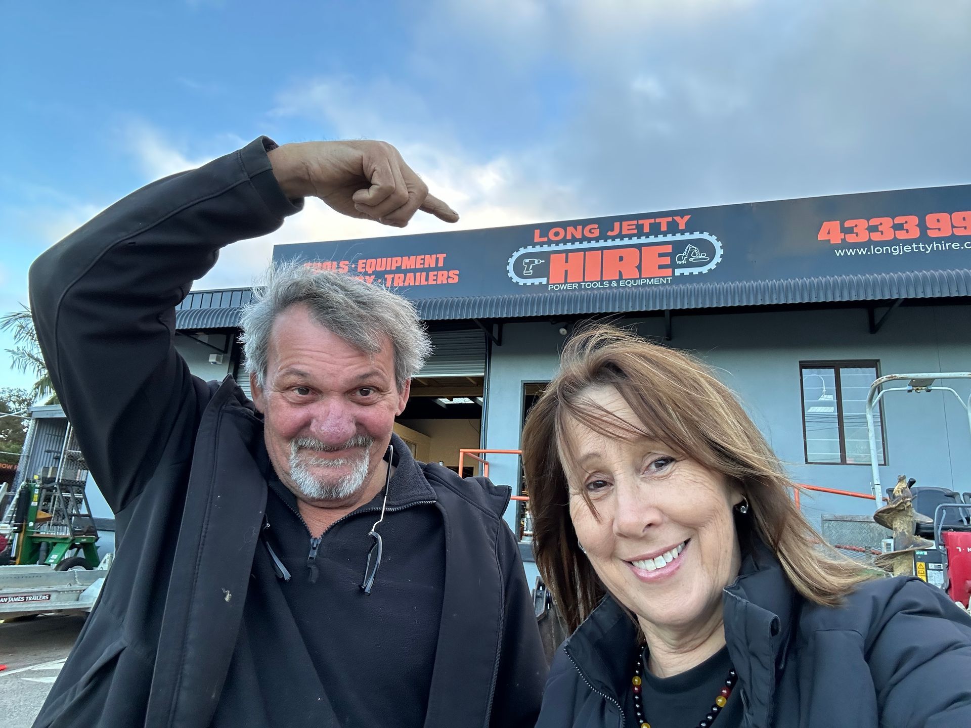 A Man And A Woman Are Standing In Front Of A Long Jetty Hire Building – Central Coast, NSW - Long Jetty Hire