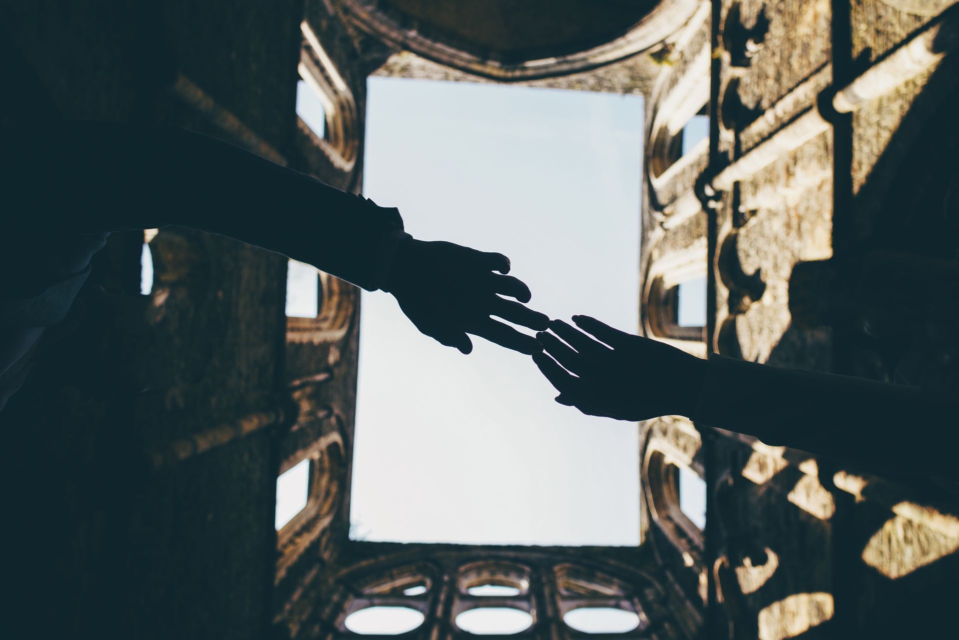 A couple of people are holding hands in a building.