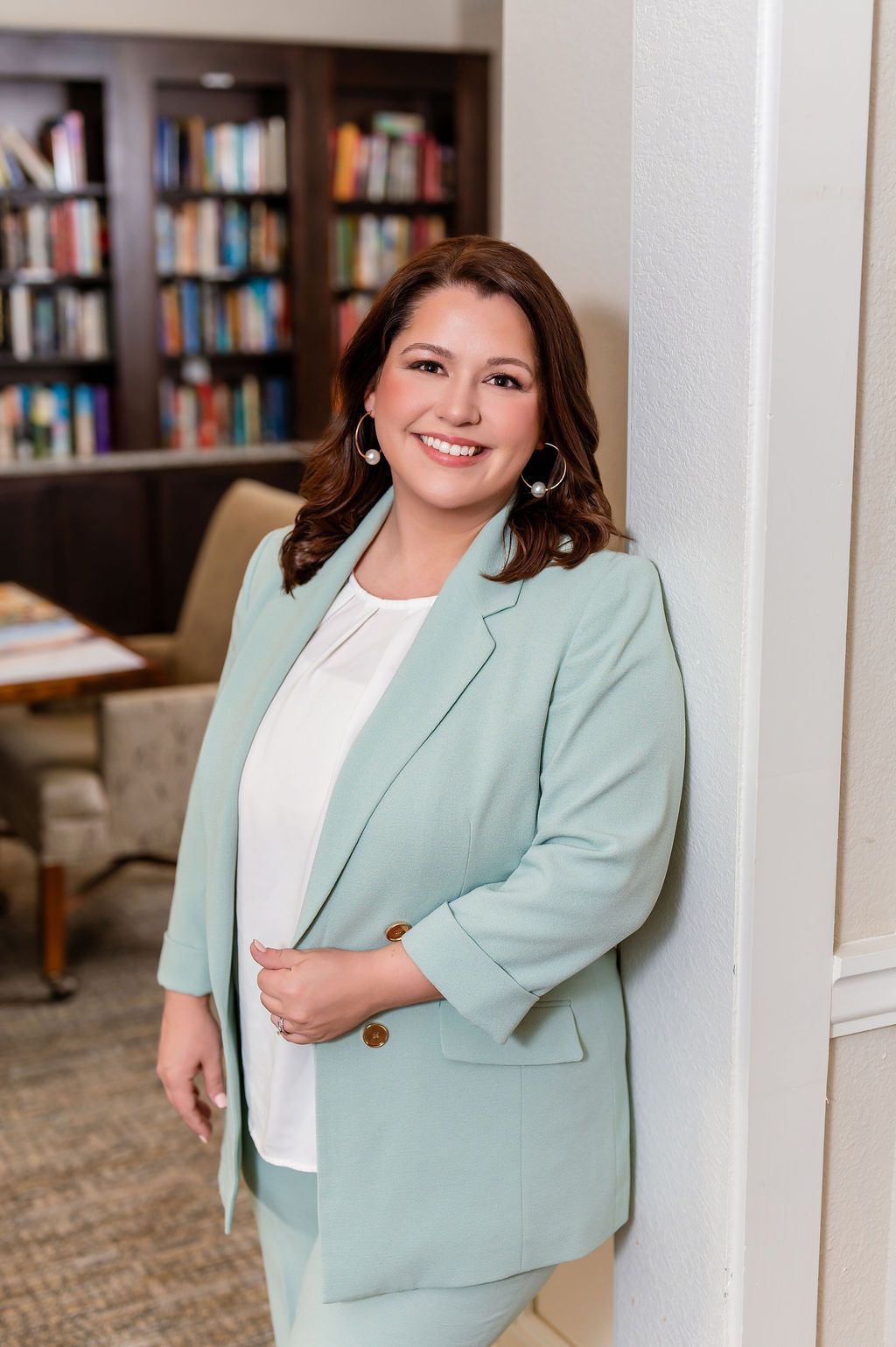 Woman in a red dress smiling, holding a phone. Against a white background.