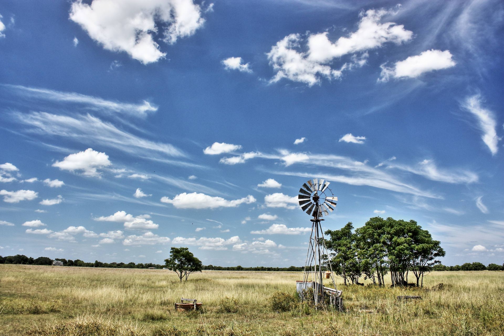 A large grassy space, windmill, and clouds near Hockley, Texas (TX)