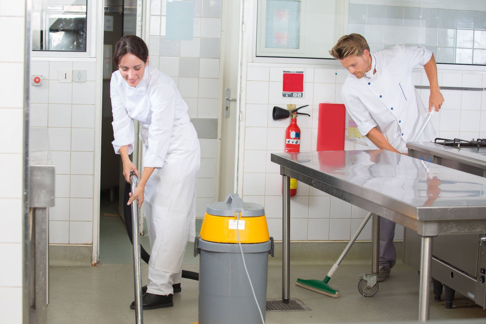 Two chefs cleaning the kitchen floor after the most recent meal service at Resilient Concrete Coatings near Cypress Texas (TX)