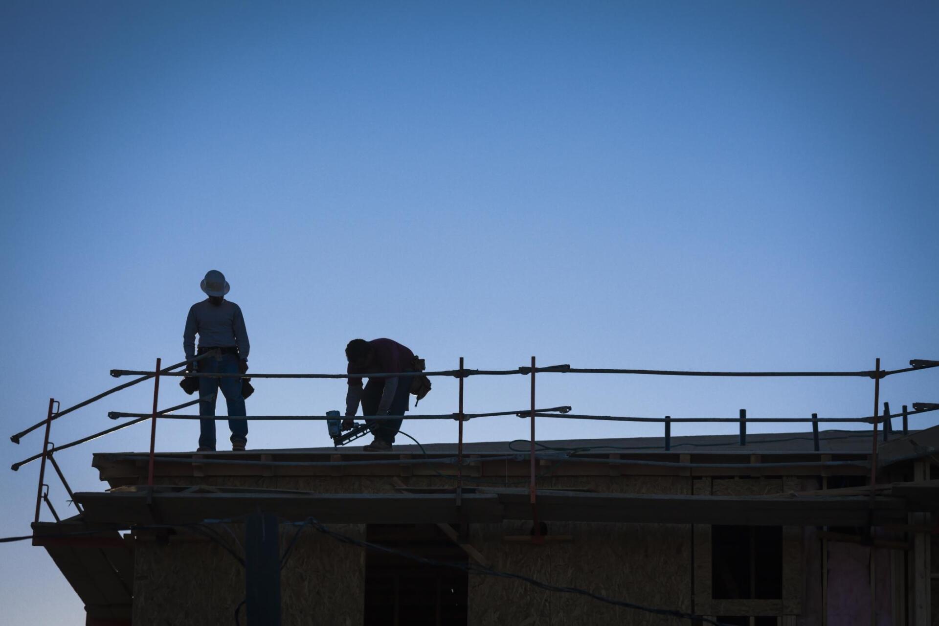 two workers repairing the roof