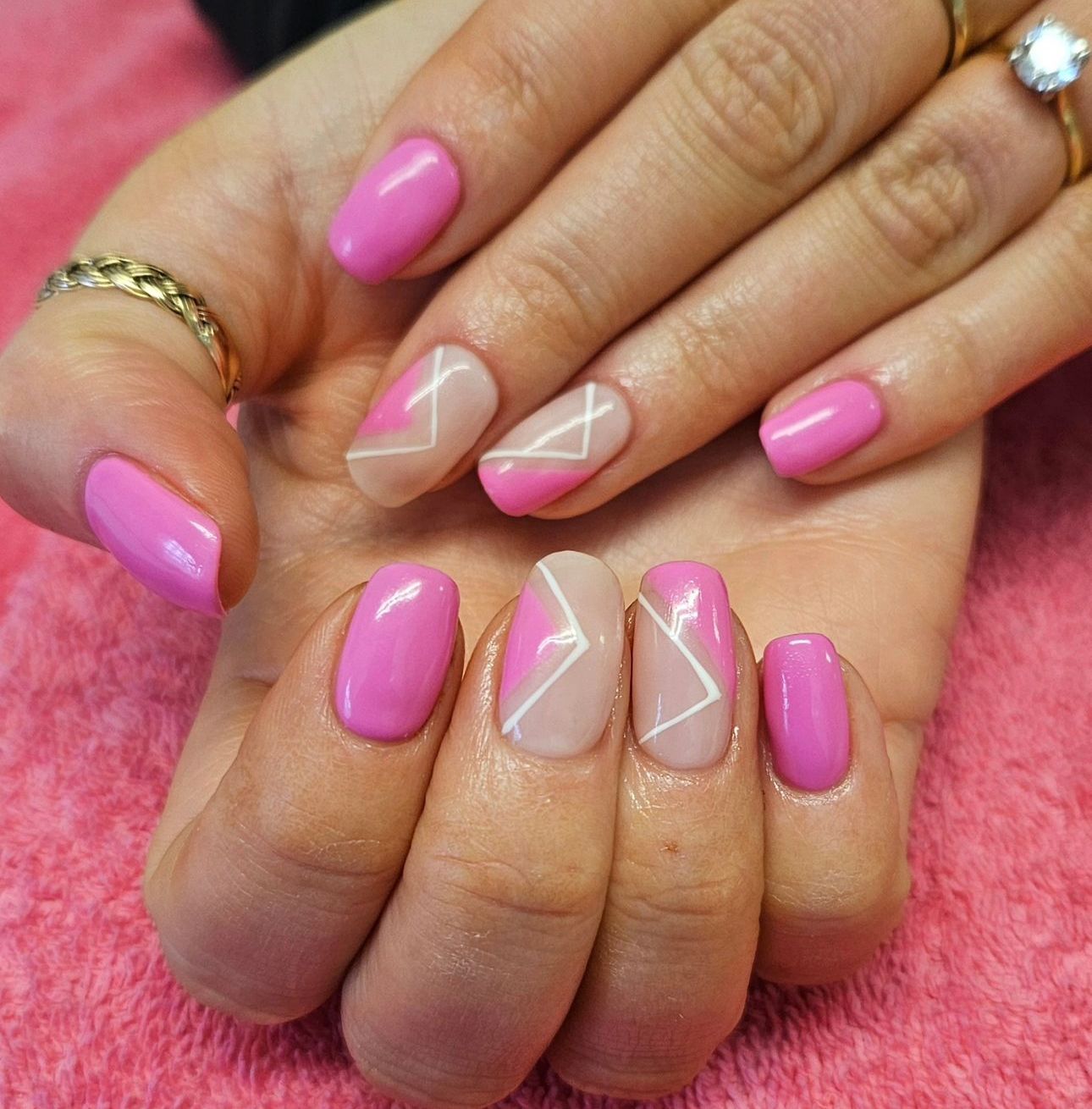 A woman 's hand with pink  gel nails