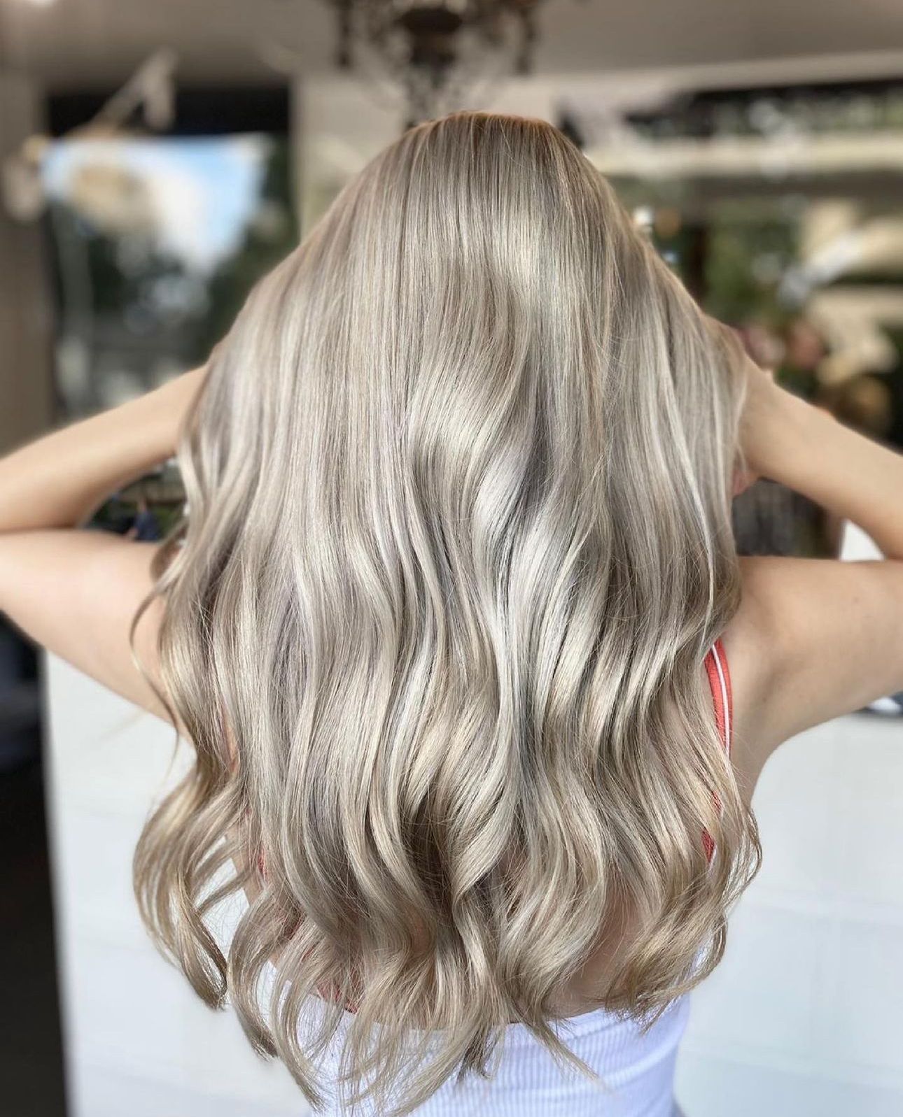 A woman with long blonde hair has just had her hair cut by a professional hair stylist at a hair salon