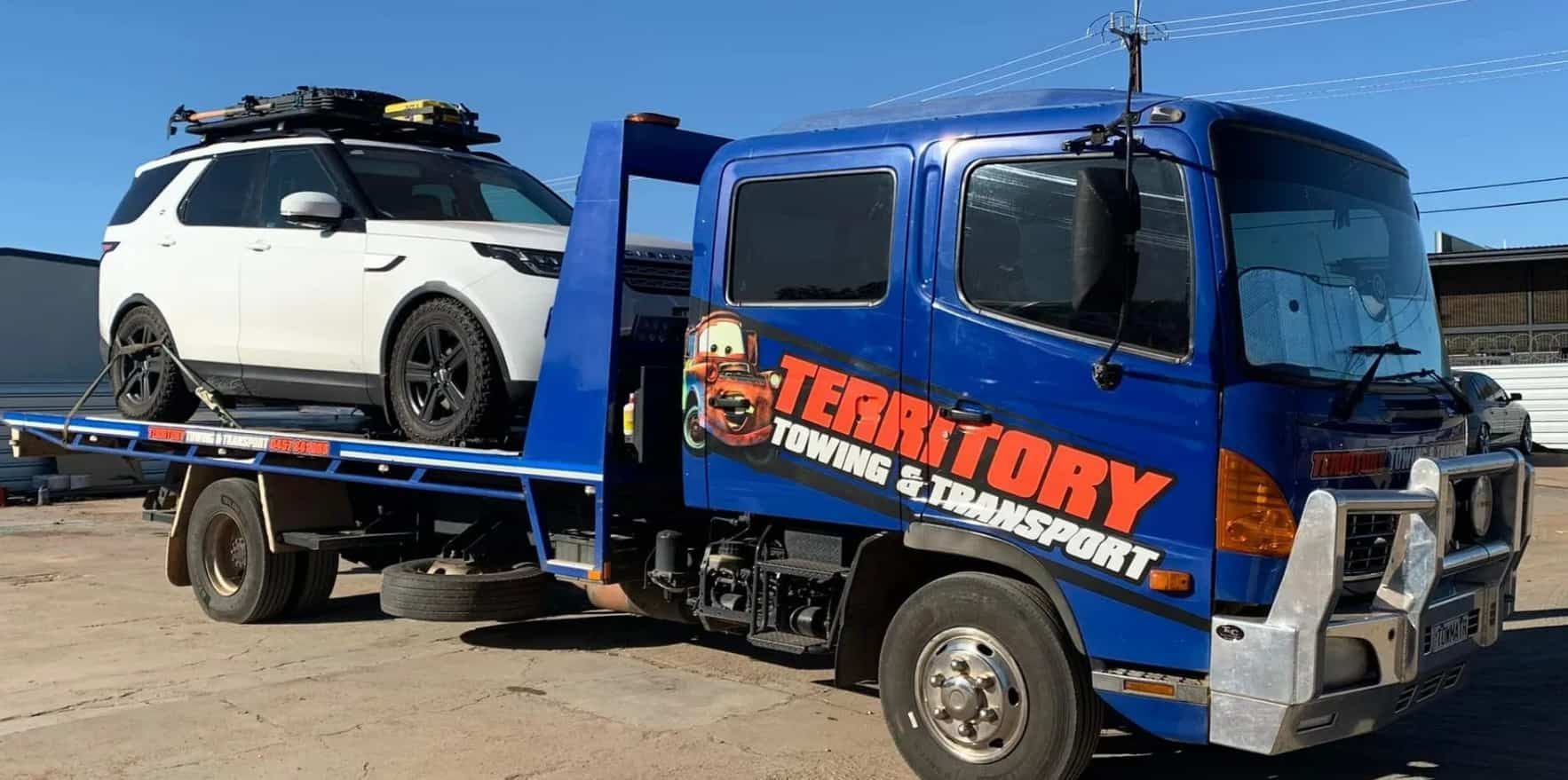 A Blue Tow Truck Is Towing A White Suv — Territory Towing & Transport In Alice Springs, NT