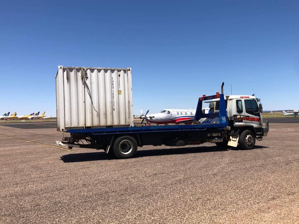 A Tow Truck With A Container On The Back Is Parked On The Side Of The Road — Territory Towing & Transport In Alice Springs, NT