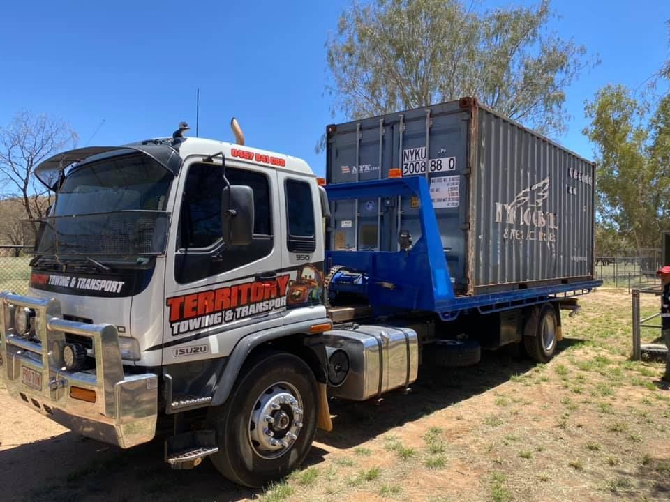 A Tow Truck With A Container On The Back Is Parked In A Field — Territory Towing & Transport In Alice Springs, NT