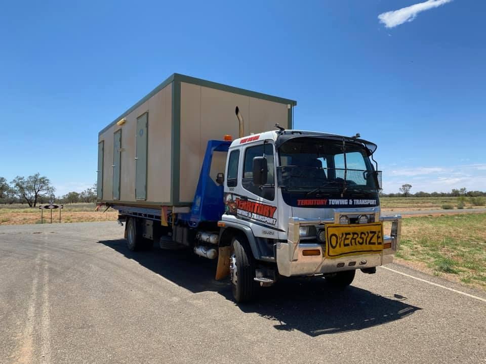 A Tow Truck Is Carrying A Container Down A Road — Territory Towing & Transport In Alice Springs, NT