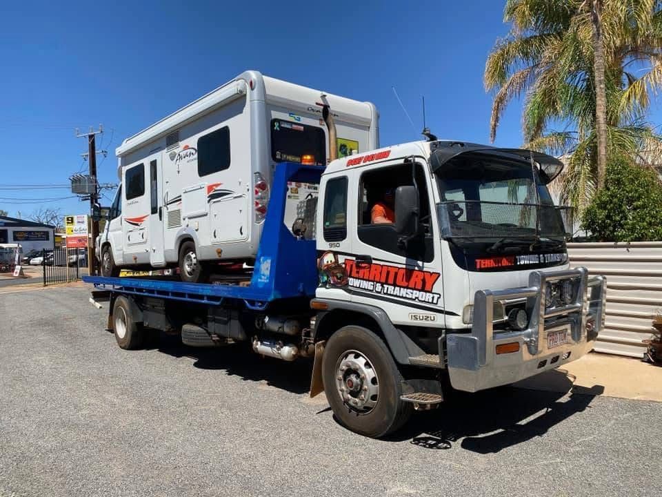 A Tow Truck Is Towing A Camper Down A Road — Territory Towing & Transport In Alice Springs, NT