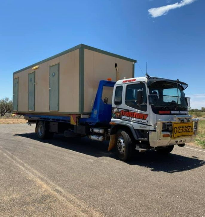 A Tow Truck With A Container On The Back Is Parked On The Side Of The Road — Territory Towing & Transport In Alice Springs, NT