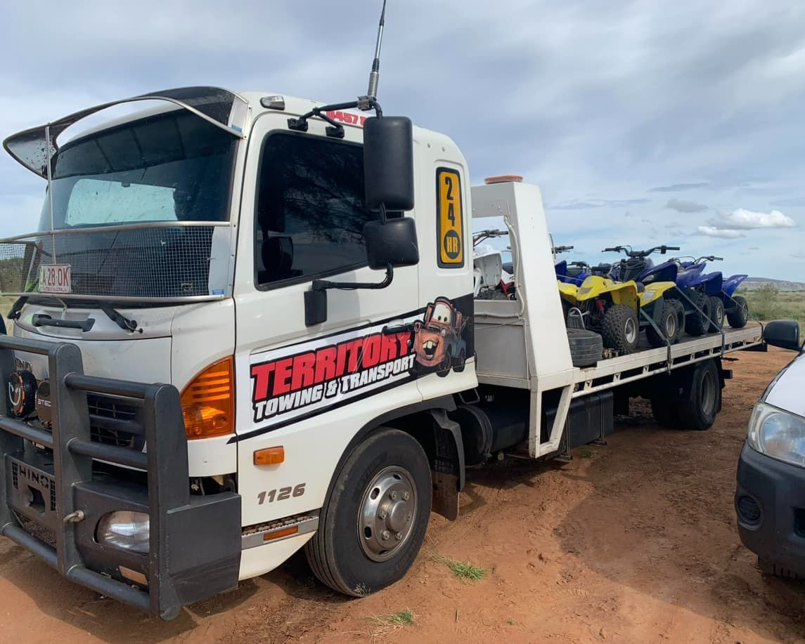 A Tow Truck Is Carrying A Bunch Of Motorcycles On The Back Of It — Territory Towing & Transport In Alice Springs, NT