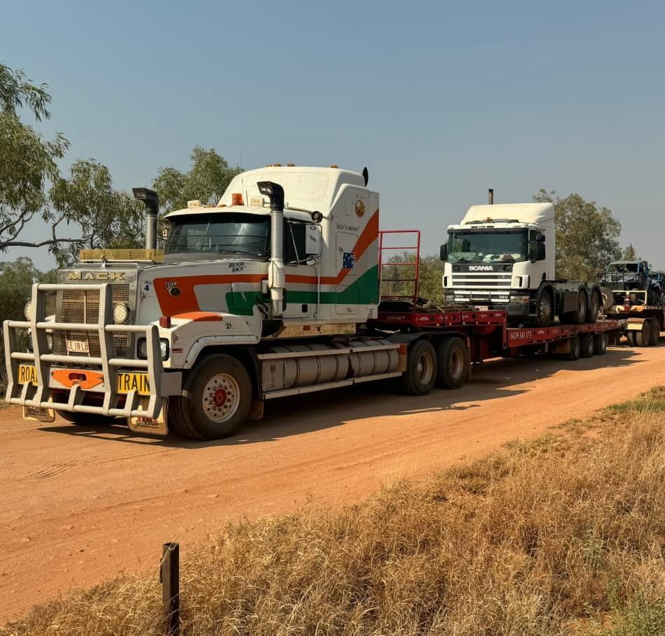 A Mack Truck Is Driving Down A Dirt Road — Territory Towing & Transport In Alice Springs, NT