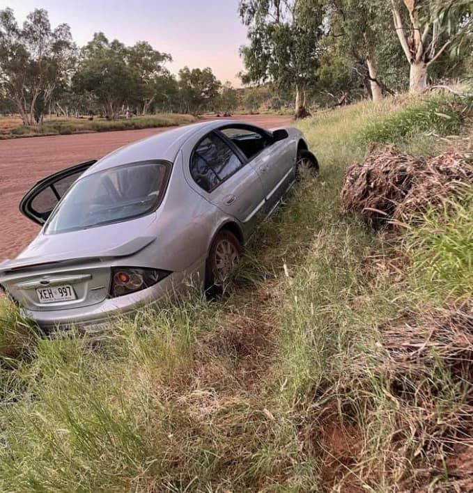 A Silver Car Is Stuck In The Grass — Territory Towing & Transport In Alice Springs, NT