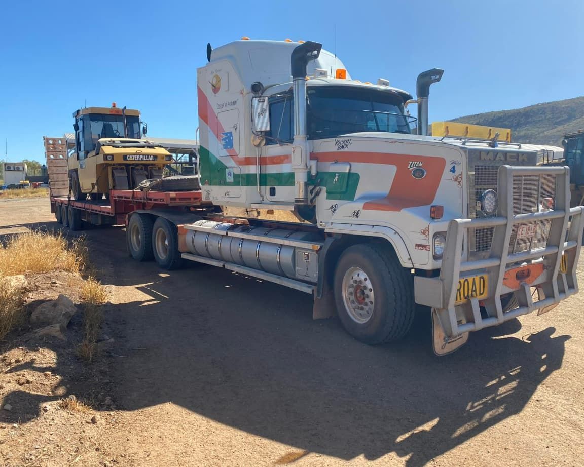 A Semi Truck Is Carrying A Bulldozer On A Trailer — Territory Towing & Transport In Alice Springs, NT