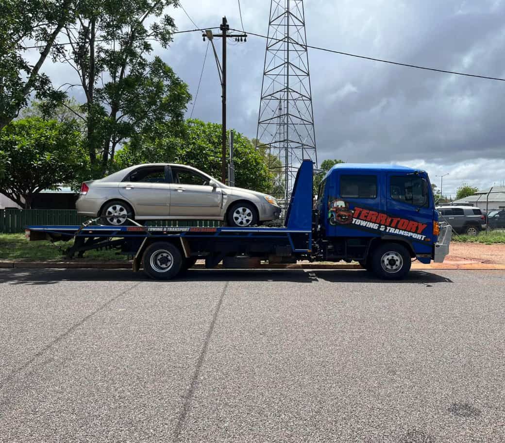 A Tow Truck Is Carrying A Car On The Back Of It — Territory Towing & Transport In Alice Springs, NT