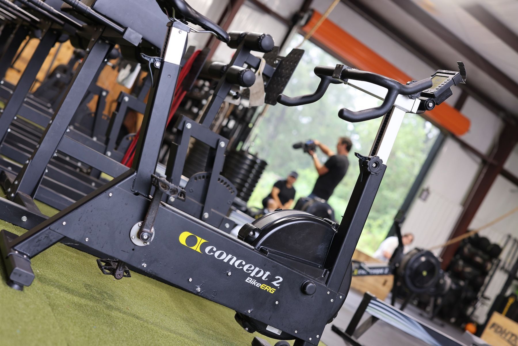 A concept 2 machine is sitting in a gym.