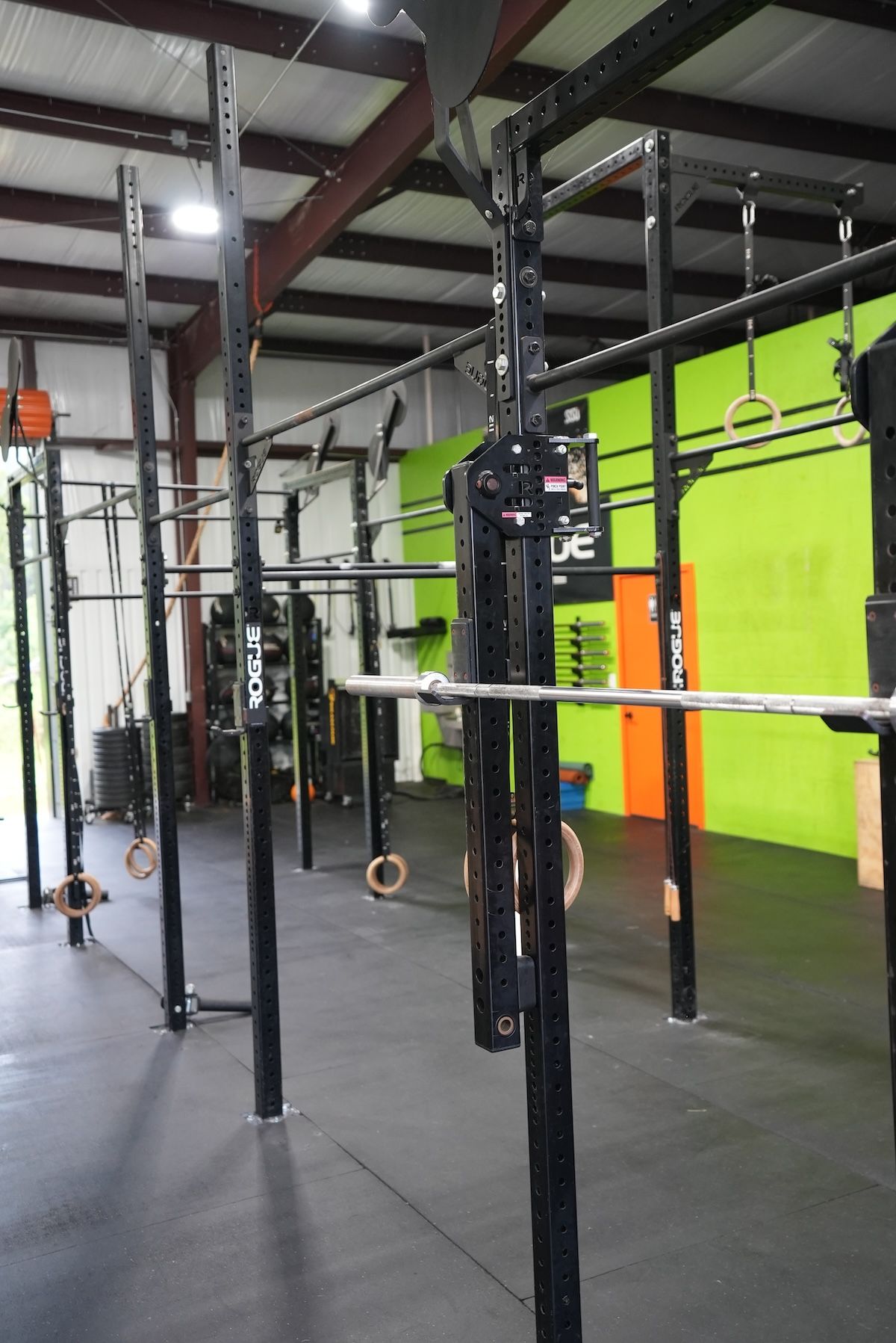 a photo from inside CrossFit Threshold gym of green wall and a bunch of bars