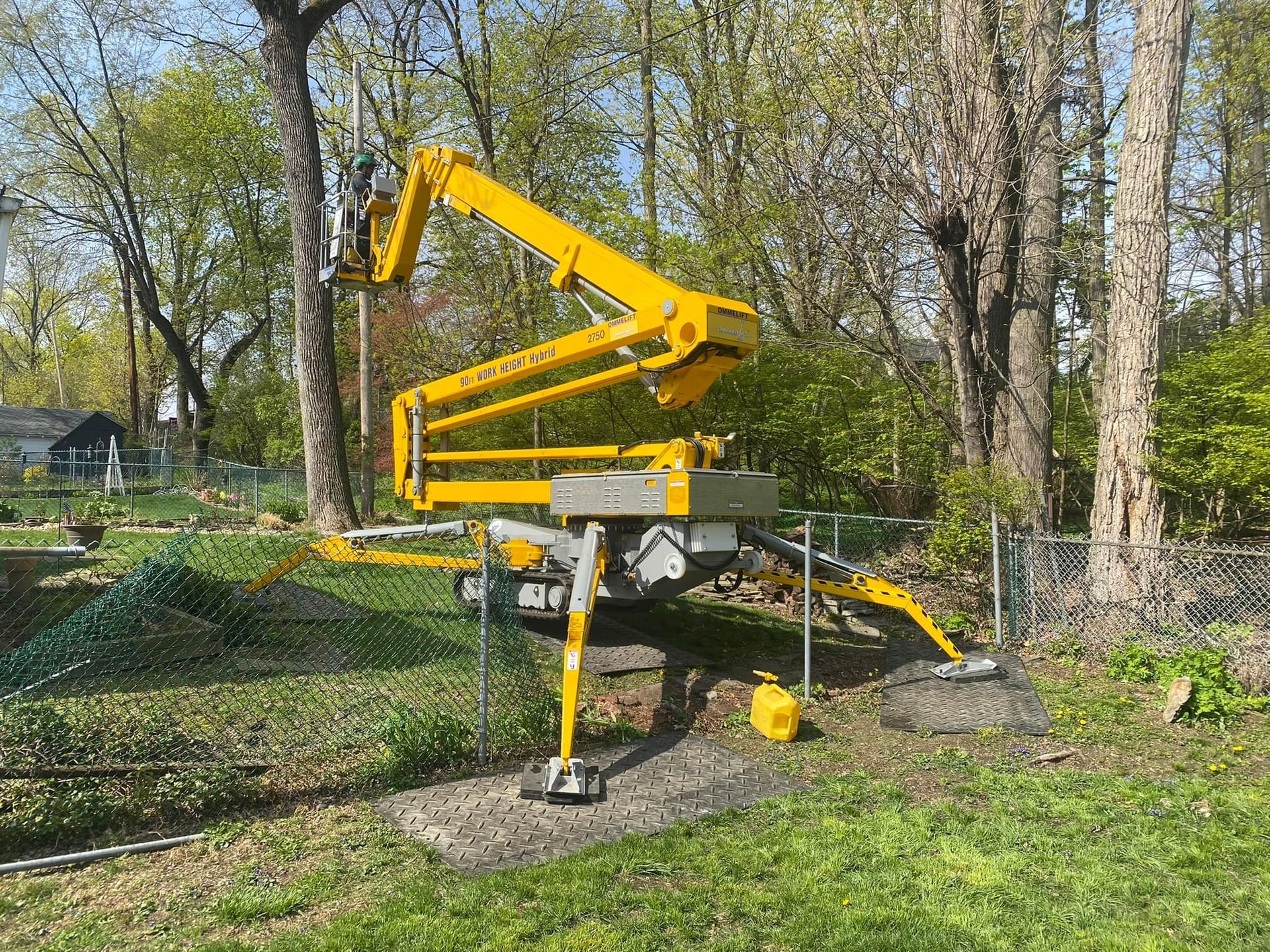 A yellow crane is sitting in the middle of a lush green field.